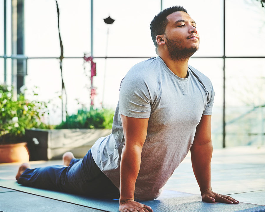 man stretching on a yoga mat