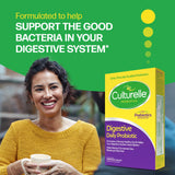 Woman holding a cup with a Culturelle Probiotics box on a green background