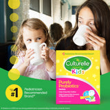 Two children and a woman drinking from mugs with a Culturelle Kids probiotics package in the foreground.
