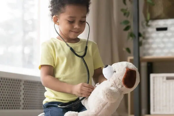 child listening to stuffed animal bear heart with stethoscope 